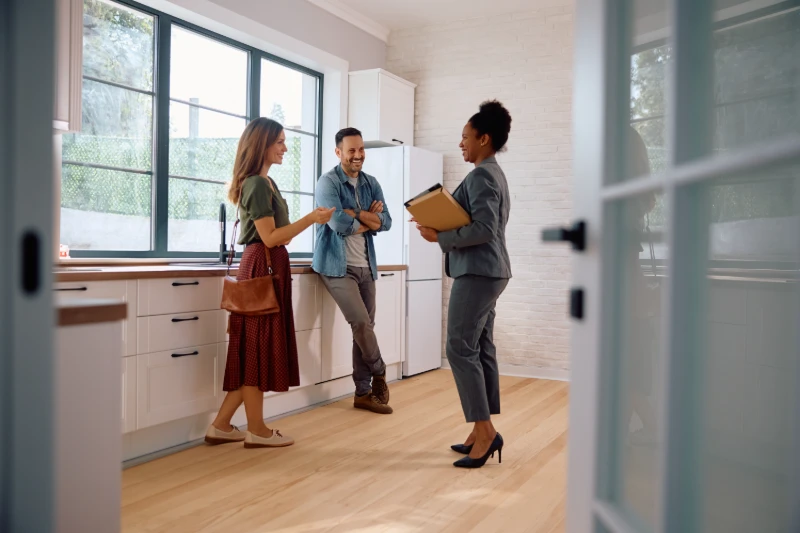 Happy-couple-talking-with-real-estate-agent-while-buying-new-hom